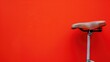 Vintage bicycle seat against vibrant red background