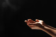 © New Africa - Religion. Woman with open palms praying on black background, closeup. Space for text