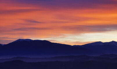 Nuvole rosse al tramonto sulla cime delle montagne