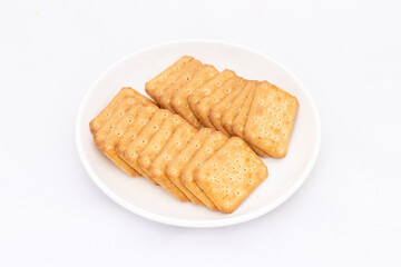 Delicious crackers with salt in plate on white background