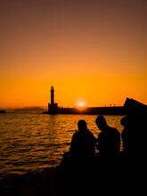 Old Lighthouse In A Port Town At Sunset (Chania, Crete, Greece)