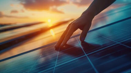 Close-up of a man's hand touching a solar panel in a beautiful sunset.