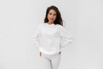 Wall Mural - Beautiful brunette girl in a white sweatshirt and leggings