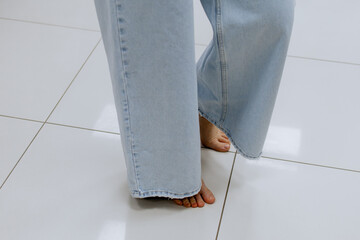 Wall Mural - Close up of woman legs tries on clothes while looking at herself in the mirror in the locker room, posing, shopping for casual clothes, in fashionable women's clothing store, in boutique. Shopping.