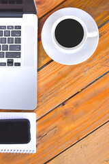 Modern white office desk table with laptop, notepad, smartphone and other supplies with cup of coffee. Top view, flat lay. Creative desk concept.