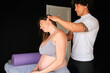 Physiotherapist massaging and stretching the neck of a pregnant woman.