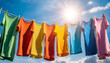 Close-up of a row of multicolored t-shirts hanging on a clothesline against a clear blue sky and sun with sunbeams and copy space. Concept of drying laundry in the sun and wind. Generative Ai.