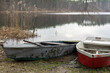 Dwie stare łódki na brzegu malowniczego małego jeziora
