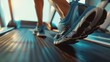 Watch as an athlete runs on a treadmill. The close-up shows their shoes pounding the belt.