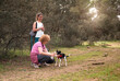Joyful Women and Playful Dog During Break on Forest Walk