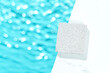 Minimal cosmetics product presentation mockup scene made with white square porous stone podium by the pool with blue water. Perfect for showcasing of beauty products.