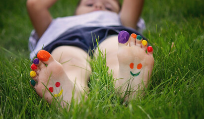 Wall Mural - a smile drawn with paints on a child's legs