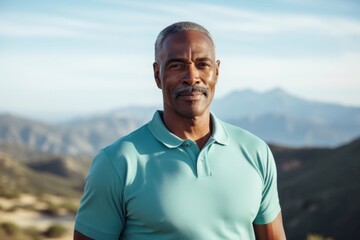 Wall Mural - Portrait of a glad afro-american man in his 50s donning a classy polo shirt in front of panoramic mountain vista