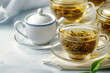 Glass cup of golden herbal tea adorned with fresh green leaves. Healthy drink concept with copy space