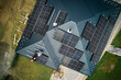 Roofers building photovoltaic solar module station on roof of house. Men electricians in helmets installing solar panel system outdoors. Concept of alternative and renewable energy. Aerial view.