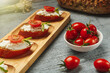 Healthy snack prepared from fresh baguette and cream cheese with tomato and greenery. Lunchtime recipe to cook at home