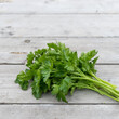 Bunch of fresh, flat-leaf parsley on a light wooden background
