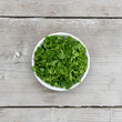 sliced ​​fresh curly parsley on a light wooden background