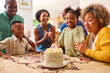 Multi-Generation Family Celebrating Granddaughter's Birthday At Home With Cake And Party