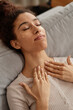 Vertical closeup of young Middle Eastern woman enjoying face and neck massage and self care day
