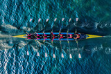 Women's rowing team on blue water, top view
