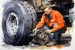 A worker inspecting the brakes on a truck