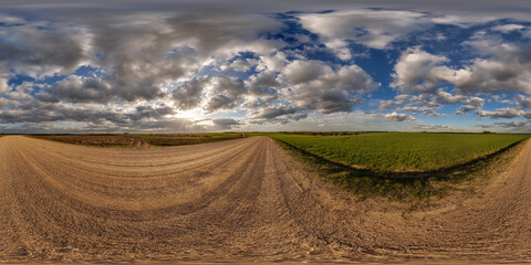Wall Mural - 360 hdri panorama view on no traffic gravel road among fields in spring day with beautiful clouds in