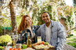 Two friends are having fun on a picnic, telling jokes, drinking drinks. A redhaired girl and an African American oy are having fun outside the city and in the company of friends.