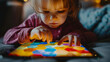 Toddler girl concentrating on a colorful puzzle.