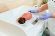 A health worker female nurse weighs the baby after delivery in the hospital room.