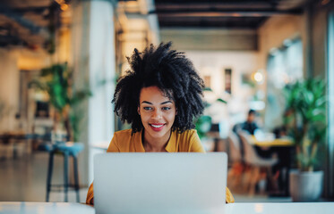 Happy african american woman worker in a vibrant coworking space. Generative AI