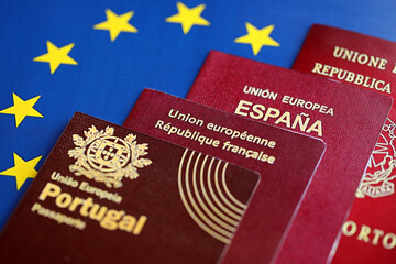 Wall Mural - European union countries passports on blue EU flag close up. Portugal, Spanish, French and Italian passports