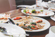 leftover food after party on wooden table in soft focus, dirty food