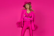 Sexy woman in pink fashionable outfit posing sensually on a pink background in the studio. Pink Glamour Fashion