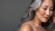 © Generative AI - Headshot of attractive middleaged Asian woman with naked shoulders and long silver hair isolated on brown fascinating mature korean lady with smooth skin looks down dreamily Skincare c : Generative AI