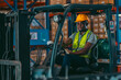 © chokniti - A man in a yellow safety vest and a hard hat is sitting in a forklift cab. He is holding a walkie talkie and smiling, foreman job to working in industrial factory storage store of global business