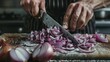Closeup of hands and knife as person precisely chops onions on a cutting board