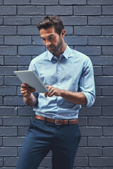 Poster - Business man, tablet and web research, reading email or info online on a wall background in city. Serious, digital tech and professional scroll on app, typing and salesman networking on internet