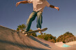 Close up of young man doing tricks on his skateboard at the skate park. Active sport concept