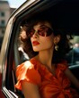 A woman in a vibrant red dress relaxes in the back seat of a luxurious car