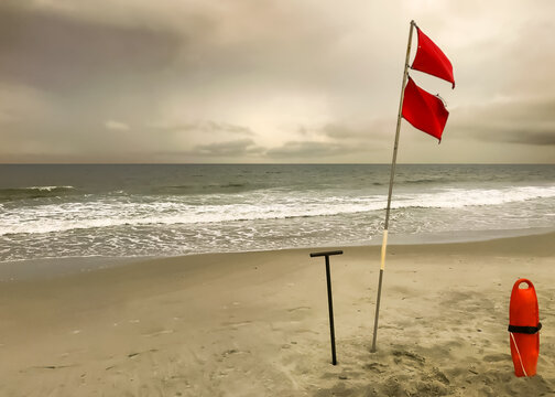 Red flag warning posted on a beach as a storm approaches