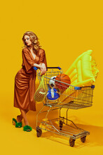 Elegant Lady Holds Mesh Bag For Fruit With Sports Ball, Shopping For Summer Items Against Yellow Studio Background. Concept Of Sport, Active Lifestyle And Healthy Eating, Contemporary Art.