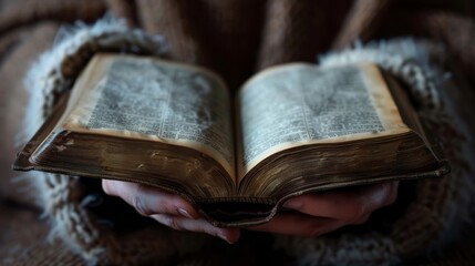 Wall Mural - A person holding an open book with gentle hands, pages fluttering slightly