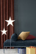 Stylish Christmas interior with a couch, stars and gifts, 3d render