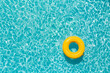 Aerial view of swimming pool transparent turquoise water. Yellow pool float, ring floating.