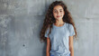 © Iqra Iltaf - Young girl wearing grey blank t-shirt and blue jeans. Concrete wall background with copy space t-shirt mockup