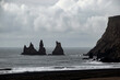 landscape of Reynisdrangar rock stack in ocean in Vik, Iceland 