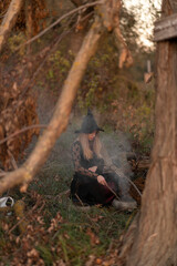 Wall Mural - A witch dressed in black dress in the forest	