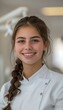 © Ilja - Young female dentist smiling in dental clinic with copy space on bright white background