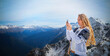 Blond woman photographing winter landscape mountains